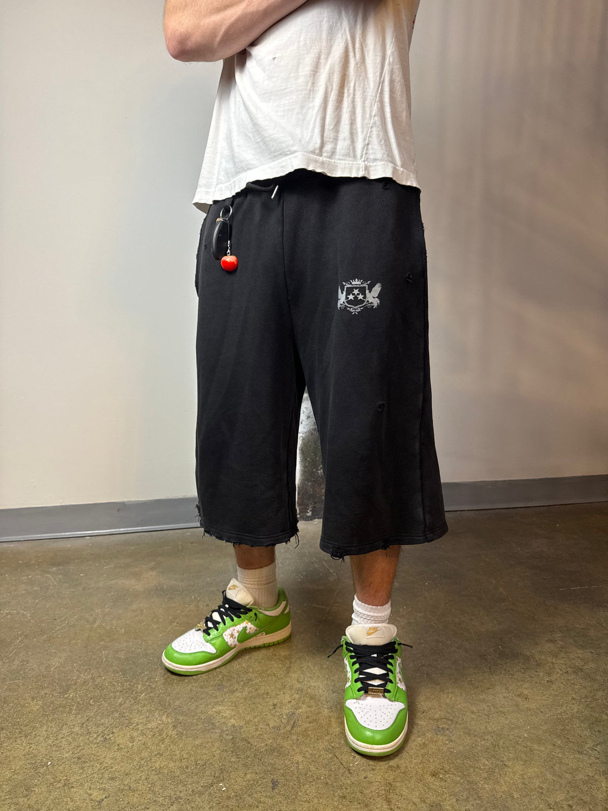Sulfur Black sweat shorts worn with a white T-shirt and green sneakers